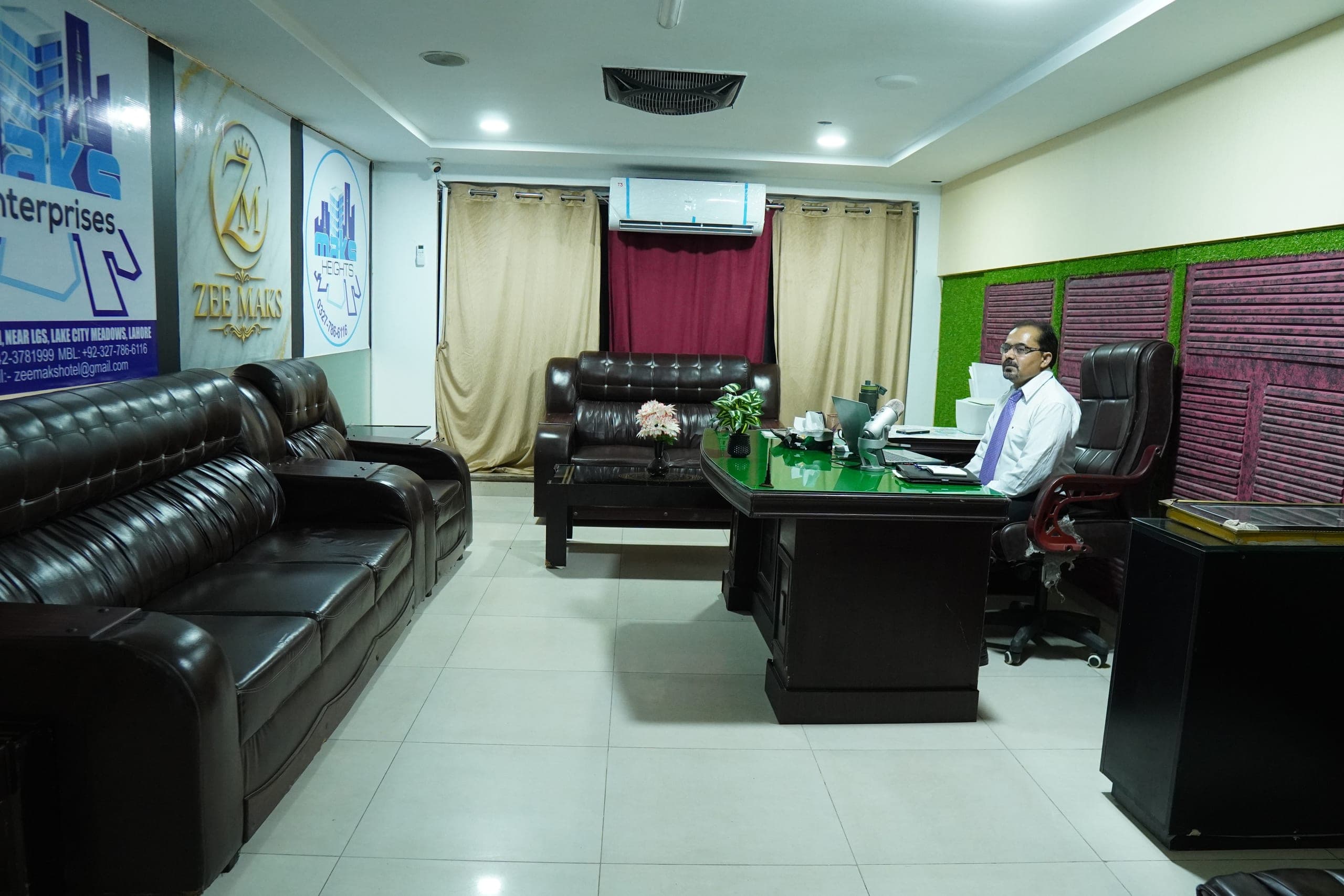 A member of the ZEE MAKS team at the desk in the guest office, with seating for visitors